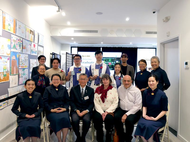 Graduating students wearing Tzu Ching sashes stand behind a seated row of chapter advisors and volunteers in Tzu Chi uniform.